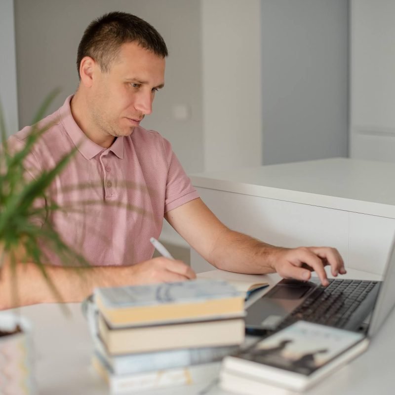 young-man-sitting-at-his-desk-with-laptop-online-t-Y49N2RK.jpg