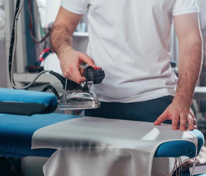 cropped-shot-of-dry-cleaning-worker-using-industri-8FECL3R.jpg